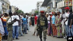 Residents of the Treichville neighborhood gather outside the damaged former base of Laurent Gbagbo's Republican Guards, as soldiers loyal to Alassane Ouattara occupy it, in Abidjan, Ivory Coast, April 15, 2011