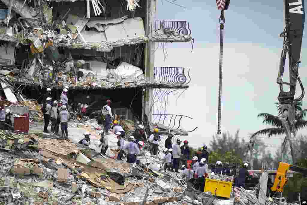 Rescue workers search in the rubble at the Champlain Towers South condominium in the Surfside area of Miami, Florida.