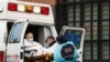 Técnicos de emergencias médicas suben a un paciente en una ambulancia fuera del Centro Hospitalario Elmhurst,en Nueva York, en medio de un brote de la COVID-19.