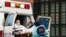 Técnicos de emergencias médicas suben a un paciente en una ambulancia fuera del Centro Hospitalario Elmhurst,en Nueva York, en medio de un brote de la COVID-19.