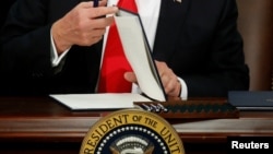 U.S. President Donald Trump prepares to sign an executive order at Homeland Security headquarters in Washington, Jan. 25, 2017.