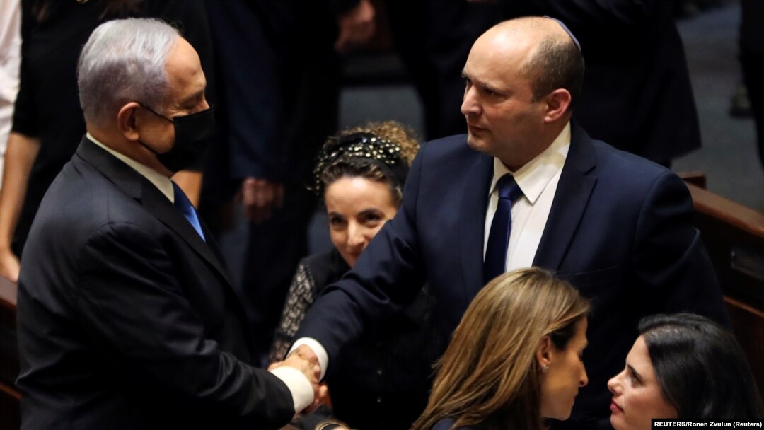 Pemimpin partai oposisi Benjamin Netanyahu menjabat tangan PM baru Israel Naftali Bennett di Yerusalem, Minggu (13/6). 