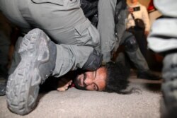 Israeli security forces detain a Palestinian man amid ongoing confrontations as Palestinian families face eviction in the Sheikh Jarrah neighborhood of East Jerusalem, May 4, 2021.