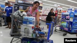 Shelly Nakasone looks through her shopping cart as she buys supplies as a hurricane and a tropical storm approach the Hawaiian islands, in Mililani, Hawaii, Aug. 5, 2014. 
