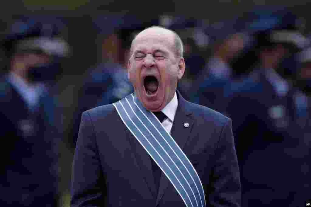 Brazilian Defense Minister Fernando Azevedo yawns during a ceremony in honor of Aviator Day at the airbase in Brasilia, Brazil, Friday, Oct. 23, 2020. (AP Photo/Eraldo Peres)