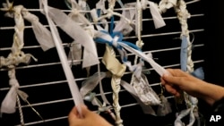 Artist Meg Saligman, at her Philadelphia studio in May, shows a mock-up of a knot installation being prepared to greet Pope Francis when he visits the city in September. The knots represent problems, and visitors are invited to leave knots or untangle the