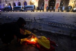 FILE - A demonstrator burns a Spanish flag at a protest in front of Catalonia's parliament on Catalonia's National Day, in Barcelona, Spain, Sept. 11, 2019.