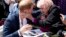 Britain's Prince Harry is embraced by 98-year-old Daphne Dunne during a walkabout outside the Opera House in Sydney, Australia, Oct. 16, 2018.