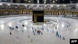 Petugas kebersihan membersihkan lantai di dekat Ka'bah, Masjidil Haram di Mekkah yang masih tertutup untuk ibadah umrah selama pandemi Covid-19. 