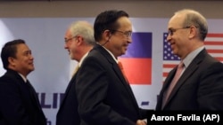 U.S. Assistant Secretary of State Daniel Russel, right, shakes hands with Philippine Undersecretary of Foreign Affairs Evan P. Garcia,after their press conference on the fifth Philippines-United States Bilateral Strategic Dialogue in Manila, Philippines Wednesday, Jan. 21, 2015. (AP Photo/Aaron Favila)