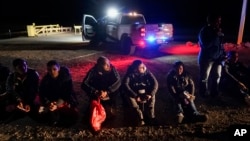 Un grupo de migrantes espera a ser procesado tras ingresar a Estados Unidos de manera irregular cerca de Yuma, en Arizona, el 6 de enero de 2023.
