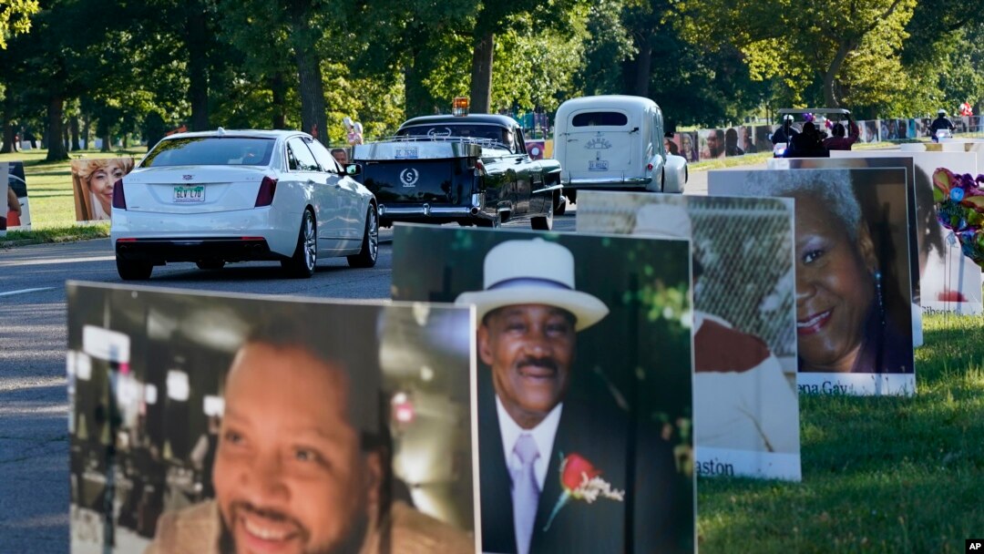 Prosesi kendaraan melewati foto-foto korban Covid-19, Senin, 31 Agustus 2020 di Belle Isle di Detroit, AS. (Foto: AP)