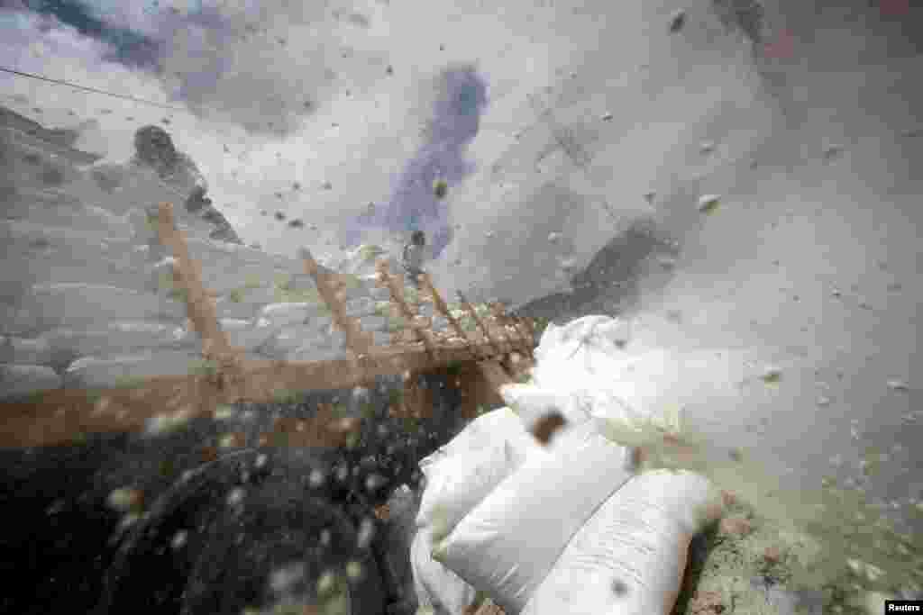 Workers dispose sacks of wheat flour which are reportedly expired after they were provided by the World Food Program, on the outskirts of Sanaa, Yemen.
