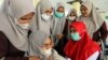 A college student reacts as she receives a vaccine dose against COVID-19 during a mass vaccination program at a campus in Lhokseumawe, Aceh province, on September 14, 2021. (Antara Foto/Rahmad/via Reuters)
