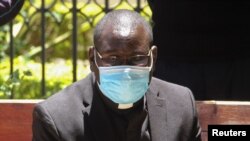 Kenyan Catholic priest Richard Onyango Oduor sits on an open-air dock as he was charged at the Milimani Law Courts with spreading the coronavirus, in Nairobi, Kenya, April 16, 2020. 