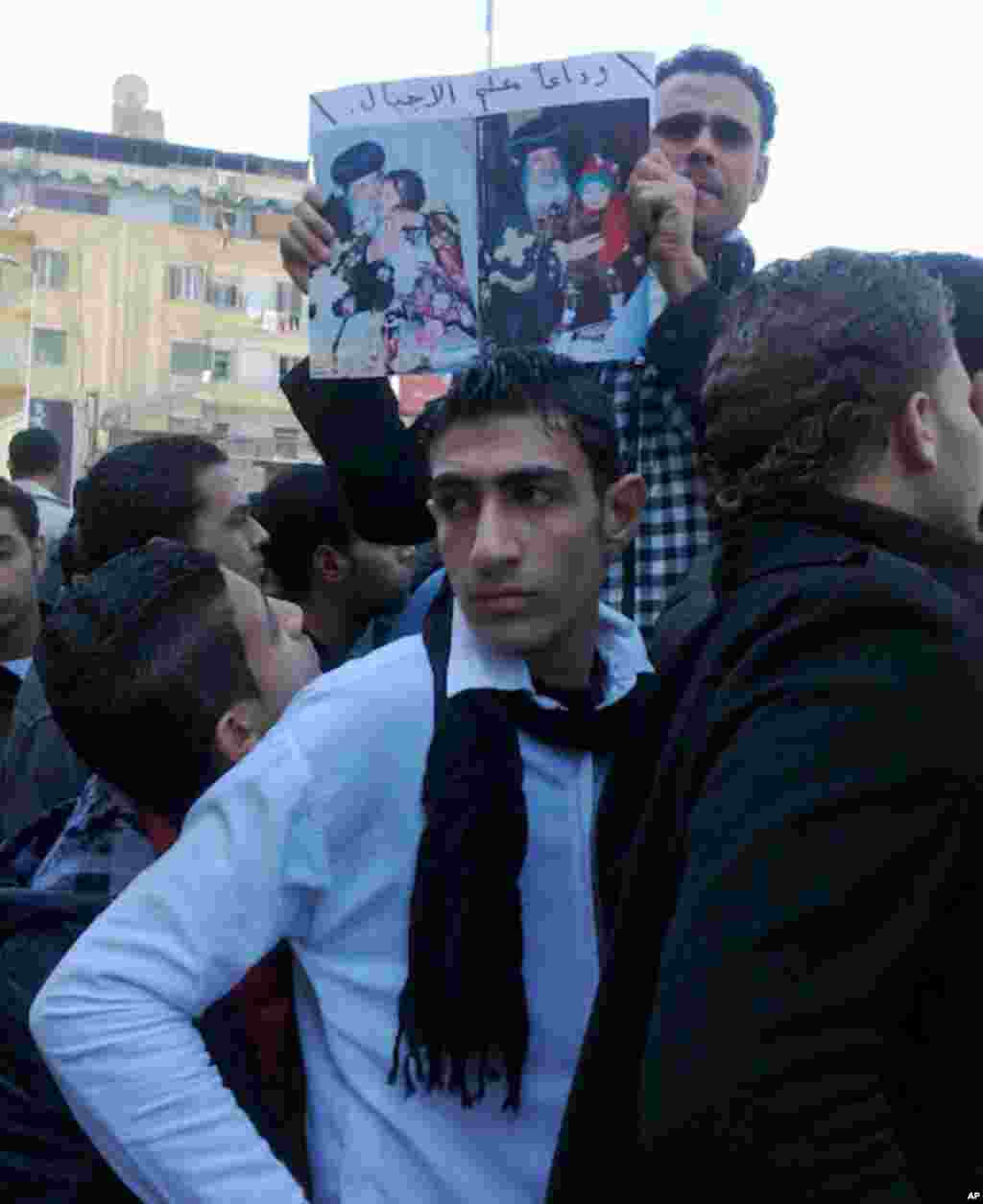 A mourner holds photos of Pope Shenouda outside the Abassaya Cathedral in Cairo. (VOA-N. el Hamzawi)