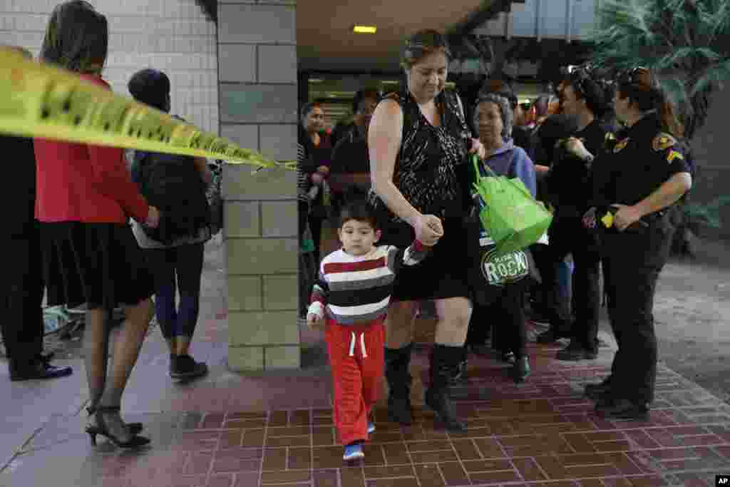 People who were near a shooting rampage that killed multiple people at a social services center, Dec. 2, 2015, leave a community center after they reunited with friends and family in San Bernardino.