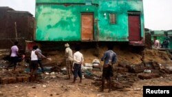 Para nelayan membersihkan puing-puing dari rumah mereka yang rusak akibat dihantam Siklon Phailin di wilayah Puri, bagian timur negara bagian Odisha (14/10).