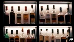 FILE - A vast array of fine single malt Scotch bottles are seen in a display case at a bar, in Boston, Massachusetts, Dec. 10, 2019. 