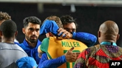 Afghanistan's captain Rashid Khan (C) greets South Africa's David Miller following South Africa's victory in the ICC men's Twenty20 World Cup 2024 semi-final cricket match between South Africa and Afghanistan at Brian Lara Cricket Academy in Tarouba, Trin