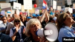 A woman uses a megaphone during a protest billed "Croatia can do better," against what demonstrators say is political meddling in education reform, on Zagreb's main square, Croatia, June 1, 2016.