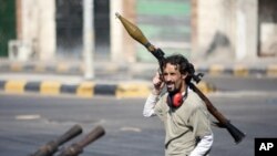 图为一名利比亚反政府武装人员8月17日携带火箭弹活动在迪黎波里以西大约50英哩处的塞卜拉泰