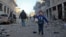 FILE - A Syrian boy runs while carrying bread following a reported airstrike by government forces, in the Syrian town of Binnish, on the outskirts of Idlib.