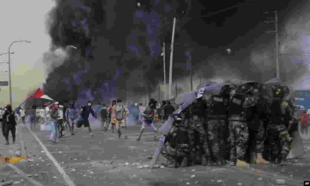 Farmworkers throw rocks at police on the Pan-American South Highway as they protest the Agricultural Promotion Law in the Barrio Chino neighborhood of Peru's Ica province, Dec. 22, 2020.