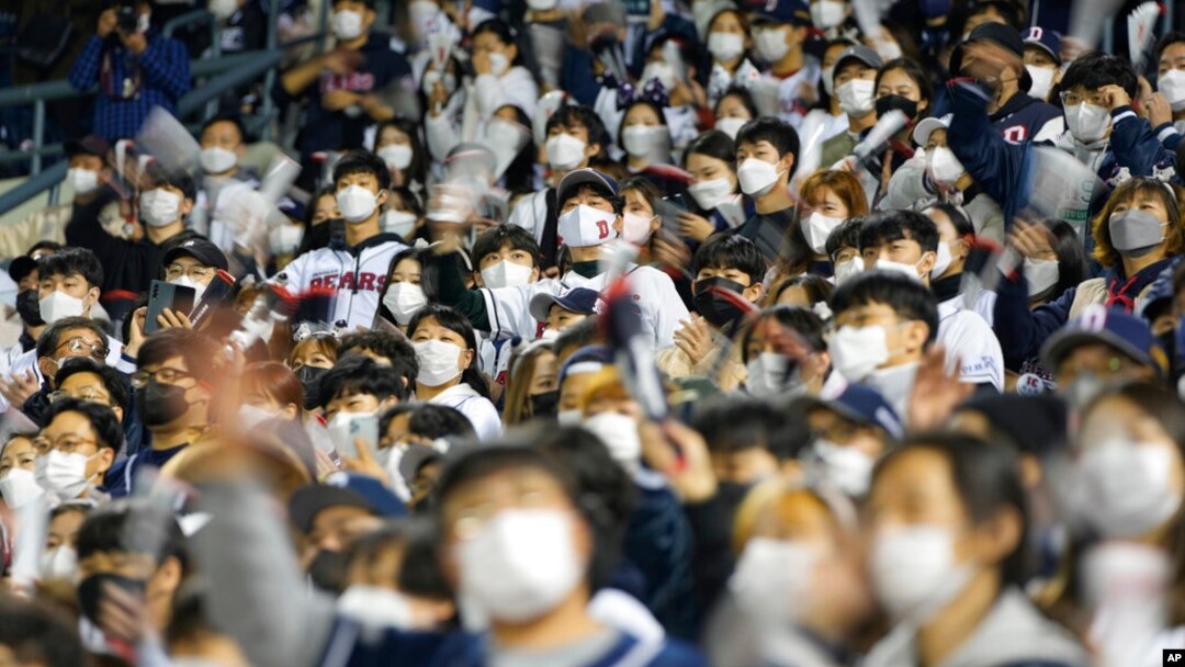 Baseball fans cheer their teams during a game between Kiwoom Heroes and Doosan Bears in Seoul, South Korea, Nov. 1, 2021. 