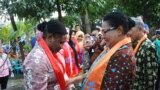 Menteri Pemberdayaan Perempuan Dan Perlindungan Anak Yohana Yambise mengalungkan selendang kepada anggota Srikandi Sungai dari Sorong, Papua pada peresmian sekolah Srikandi Sungai di Yogyakarta Sabtu petang (10/6). (Foto VOA/Munarsih Sahana)