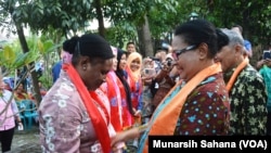 Menteri Pemberdayaan Perempuan Dan Perlindungan Anak Yohana Yambise mengalungkan selendang kepada anggota Srikandi Sungai dari Sorong, Papua pada peresmian sekolah Srikandi Sungai di Yogyakarta Sabtu petang (10/6). (Foto VOA/Munarsih Sahana)