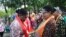 Menteri Pemberdayaan Perempuan Dan Perlindungan Anak Yohana Yambise mengalungkan selendang kepada anggota Srikandi Sungai dari Sorong, Papua pada peresmian sekolah Srikandi Sungai di Yogyakarta Sabtu petang (10/6). (Foto VOA/Munarsih Sahana)