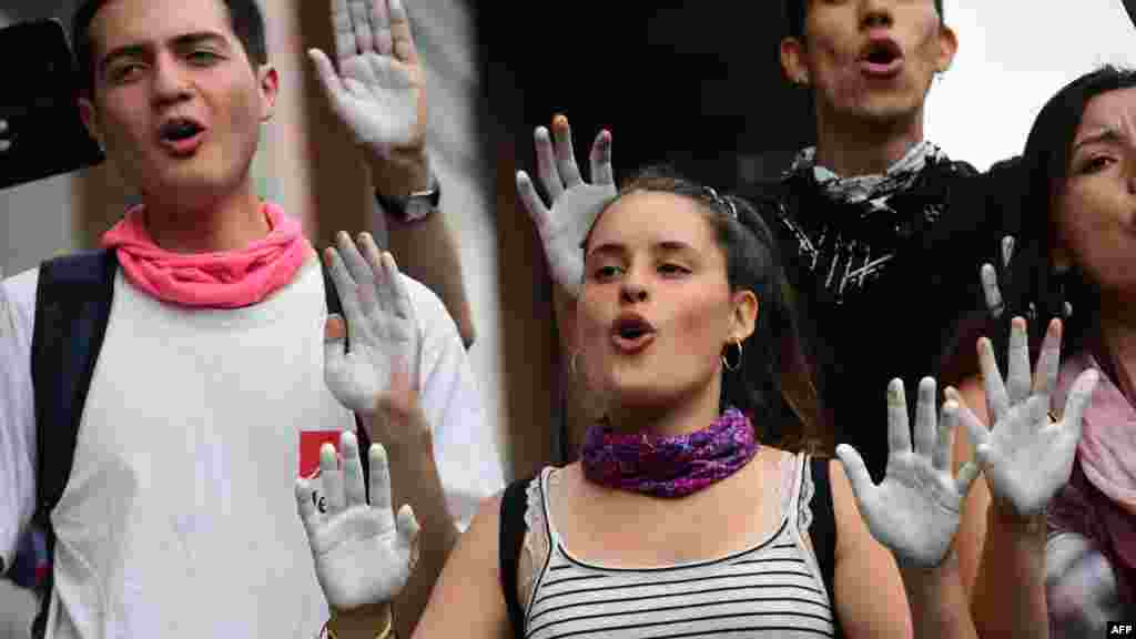 Estudiantes chilenos muestran sus manos pintadas de blanco en señal de protesta contra el gobierno y la represión del ejército contra los manifestantes.