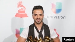 Luis Fonsi porte ses trophées pour la chanson de l'année, disque de l'année et meileur clip and meilleur morceau de Fusion pour"Despacito" .