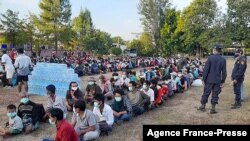 This photo taken on Dec. 16, 2021 by Metta Charity, shows people from Myanmar who fled a surge in violence sitting in lines as they are processed in Mae Tao Phae in Thailand's Mae Sot district.