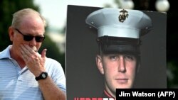 Joe Reed, the father of former U.S. Marine Trevor Reed, stands next to a placard of his son outside the U.S. Capitol in Washington, July 29, 2021. (Jim WATSON / AFP)