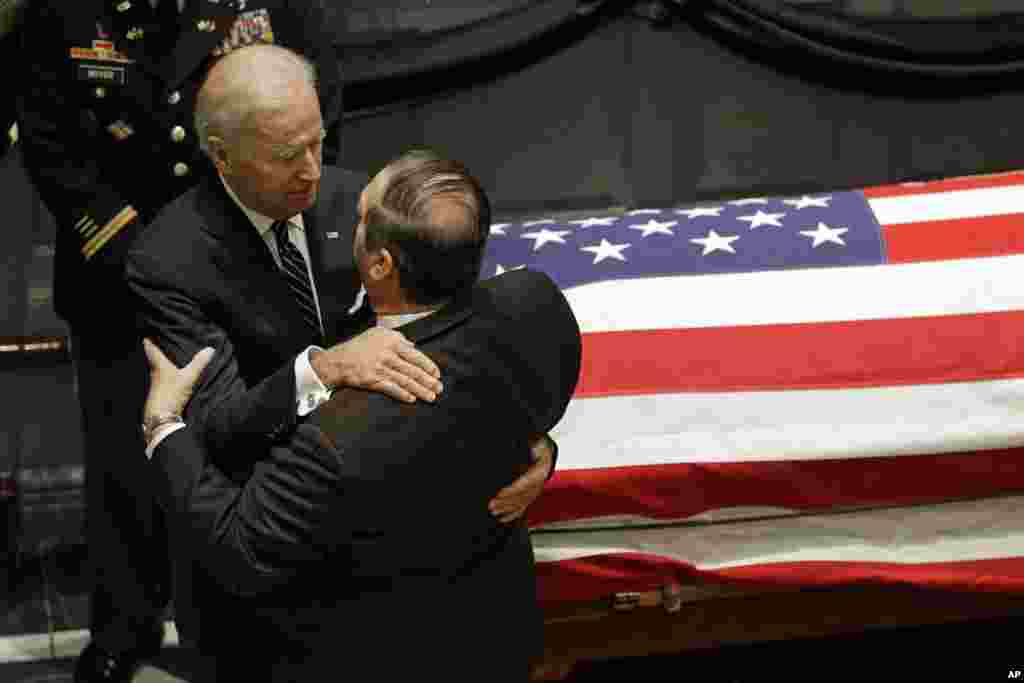 Vice President Joe Biden hugs a mourner as they stand near Beau Biden&#39;s casket during a viewing, at Legislative Hall in Dover, Delaware, June 4, 2015.