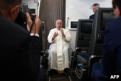 Pope Francis holds a news conference aboard the papal plane on his flight back after his 12-day journey across Southeast Asia and Oceania, Sept. 13, 2024.