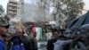 People gather near a damaged site, hauling a destroyed vehicle away, after what Syrian and Iranian media described as an Israeli air strike on Iran's consulate in the Syrian capital Damascus April 1, 2024.