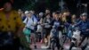 People on their bicycles and electric bikes wait at a traffic light during the morning rush hour in Beijing, Sept. 13, 2024. 