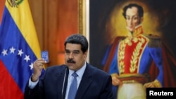 ປະທານາທິບໍດີ ເວເນຊູເອລາ ທ່ານ Nicolas Maduro ຈັບຢູ່
ໃນມື ລັດຖະທຳມະນູນແຫ່ງຊາດສະບັບນຶ່ງ ເວລາທ່ານກ່າວ ຢູ່ໃນກອງປະຊຸມນັກຂ່າວ ທີ່ວັງ Miraflores Palace ໃນນະ
ຄອນຫຼວງ ກາຣາກາສ ເວເນຊູເອລາ ວັນທີ 9 ມັງກອນ ປີ 2019. 