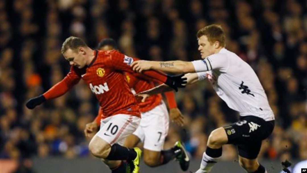 Pemain Fulham John Arne Riise (kanan) berebut bola dengan pemain Manchester United Wayne Rooney (foto: dok). 
