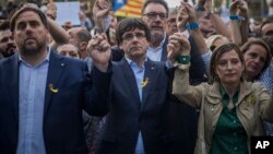 Presiden Catalonia Carles Puigdemont dan Ketua parlemen Carme Forcadell (kanan), yang kini terguling, pada aksi protes di Barcelona 21 Oktober lalu (foto: dok).