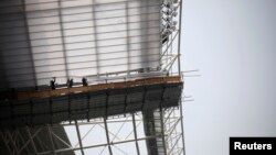 FILE - Laborers work at the Incheon Asiad Main Stadium that is being built for the 17th Asian Games in Incheon, South Korea, April 2014.