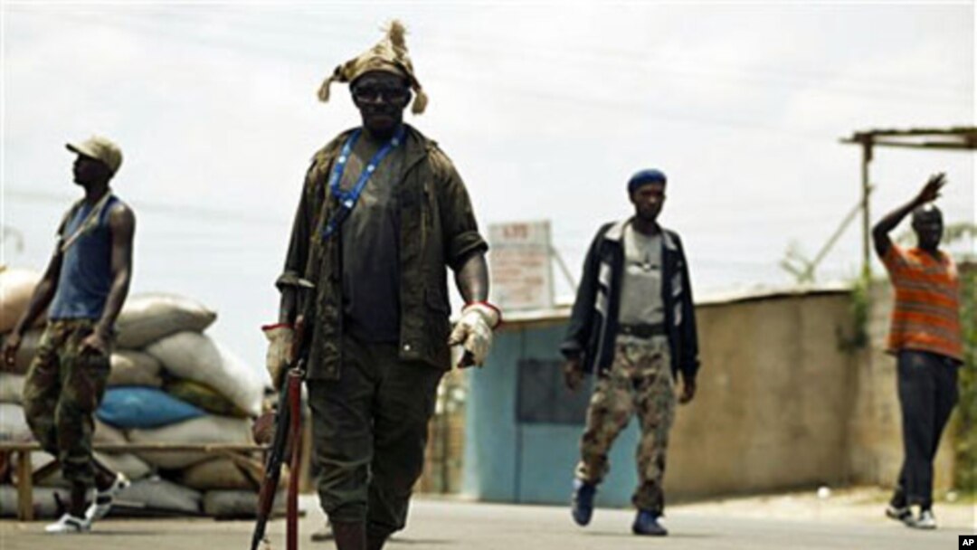 Fighters opposed to Laurent Gbagbo's bid to cling to power man a roadblock in the Abobo district of Abidjan, Ivory Coast Saturday, Mar12 2011