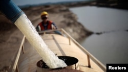 FILE - A worker fills a truck with water pumped from one of the canals being built to divert water from the Sao Francisco river for use in four drought-plagued states, near the city of Mauriti, Ceara state, Brazil, Jan. 28, 2014. 