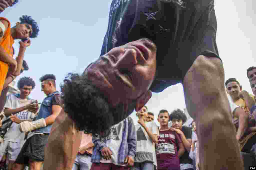 Pemuda Mesir menari breakdance sebagai bagian dari kemeriahan setelah sholat Idul Fitri di lapangan Mostafa Mahmoud di Kairo, Mesir, 25 Juni 2017. (H. Elrasam/VOA)