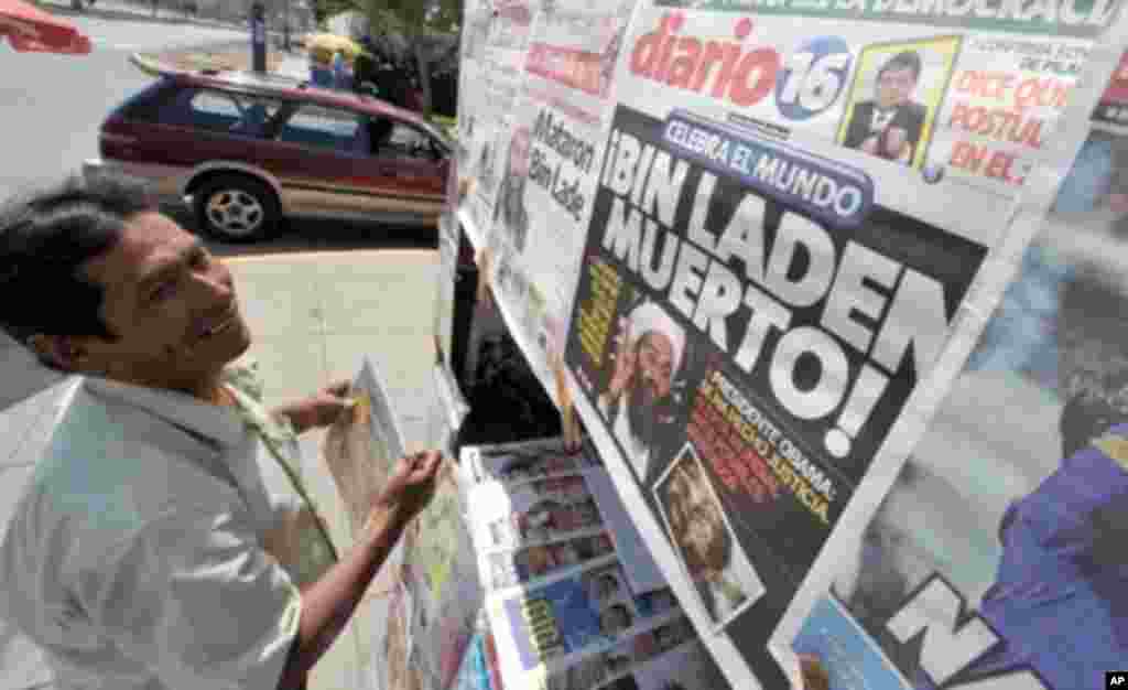 Headlines in Peruvian newspapers feature the killing of Al-Qaida leader Osama Bin Laden as a man arranges newspapers at a newsstand in Lima on May 2, 2011; President Alan Garcia said the first miracle made by Pope John Paul II, beatified Sunday in Rome wa
