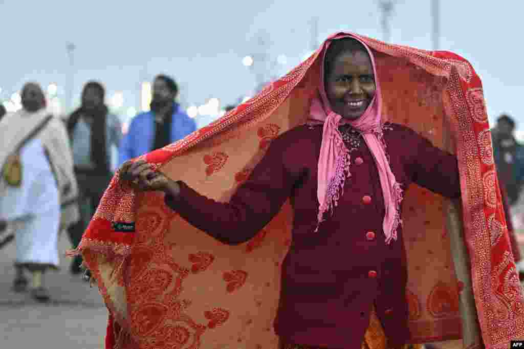 A Hindu devotee arrives to take a dip in Sangam, the confluence of Ganges, Yamuna and mythical Saraswati rivers, during the Maha Kumbh Mela festival, on a cold winter morning in Prayagraj on Jan. 13, 2025.