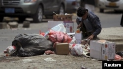 A boy searches for food amongst litter in Sanaa, April 8, 2015.